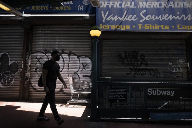 A masked person walks by a closed souvenir store across the street from Yankee Stadium in the Bronx in June 2020.